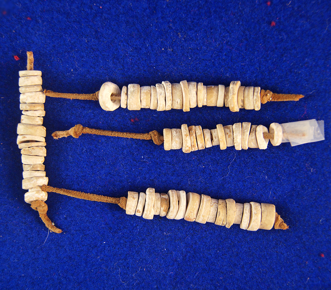 Four strands of drilled shell beads found a site in Kentucky largest is 2" long.