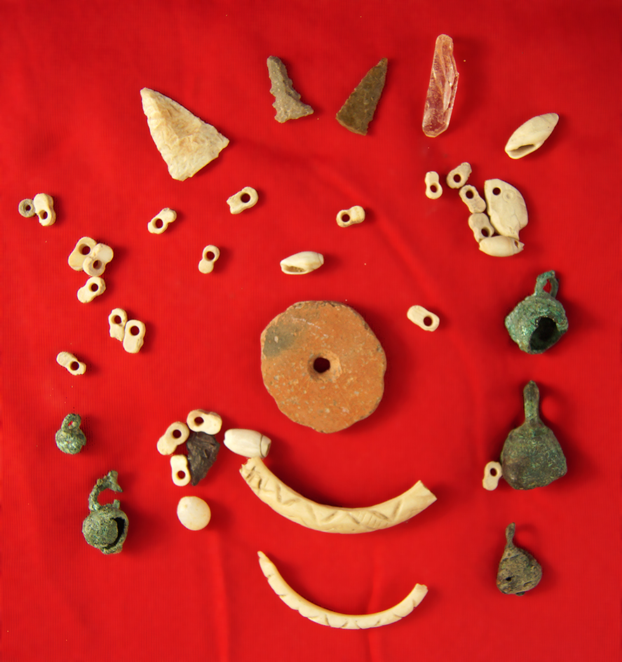 Group of assorted artifacts from  Arizona including drilled stone, Shell beads and brass bells.