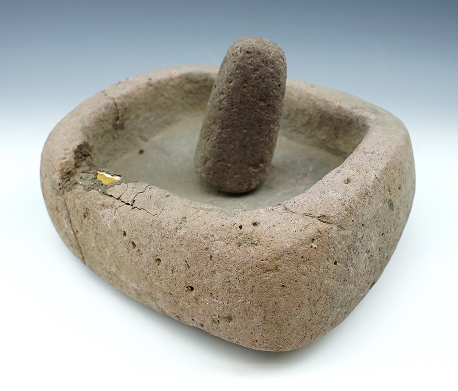 Well defined 7 1/4" wide stone bowl and a 3 1/4" pestle. One corner of the bowl is reattached.