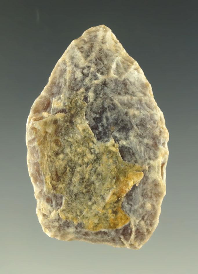 Heavily patinated Knife River Flint paleo dart point that is 1 1/2" long found in Colorado.