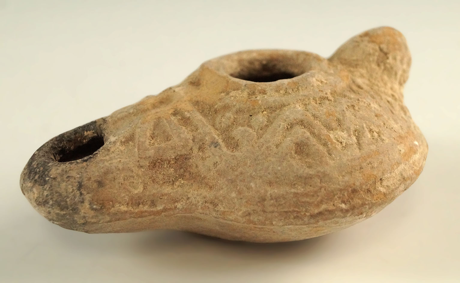 3 3/8" long Holy Lands oil lamp made from clay with heavy caliche deposits  and soot stains.