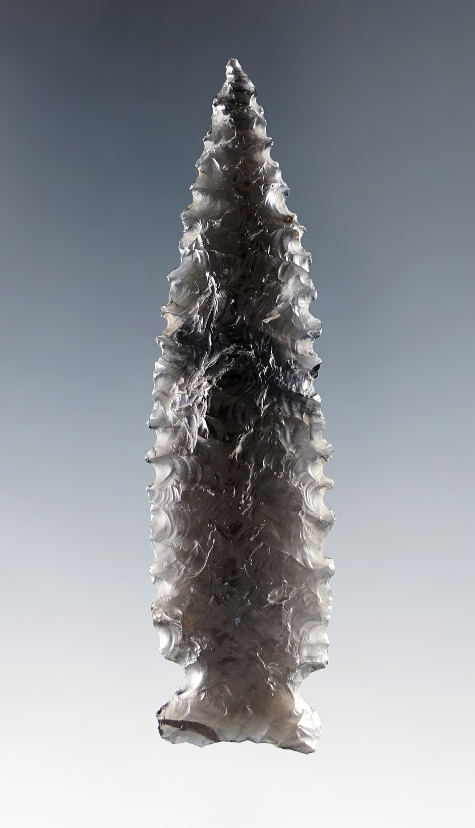 Exceptional flaking in style on this beautifully serrated 3 1/8" Sidenotch. Recovered in Nevada.